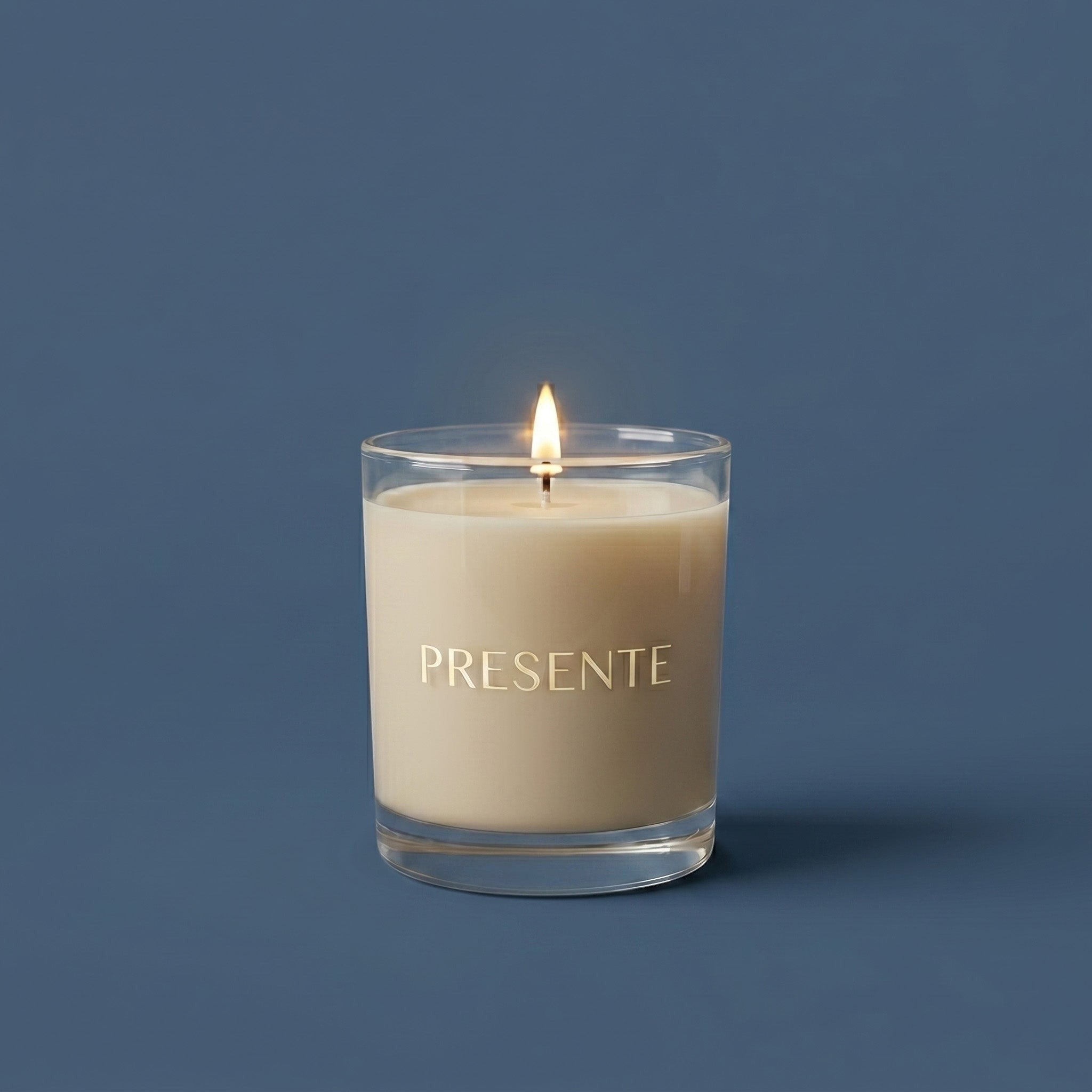 PRESENTE Taller Artesanal Serenidad Blanca No. 14 candle with lavender, coconut, and vanilla notes in a clear glass jar.  PRESENTE Vela Taller Artesanal Serenidad Blanca No. 14 con notas de lavanda, coco y vainilla en frasco de vidrio transparente.