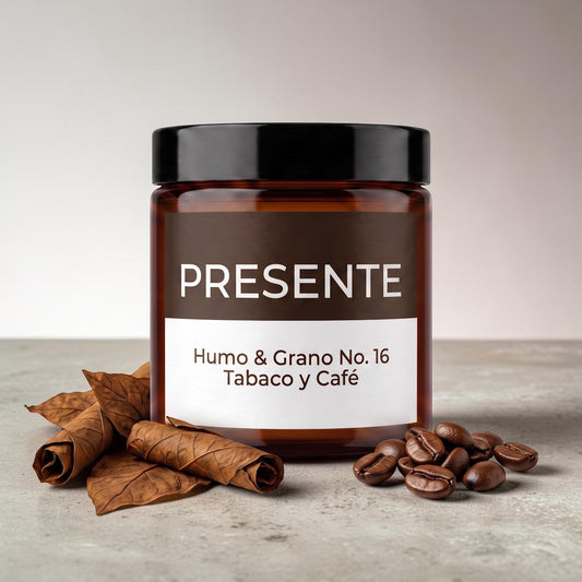 Vela aromática PRESENTE Taller Artesanal Humo & Grano No. 16 en frasco ámbar con granos de café y hojas de tabaco seco.