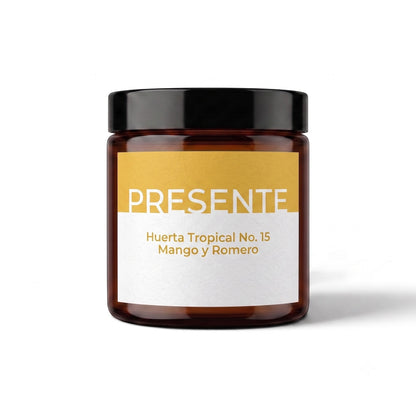 Vela aromática PRESENTE Taller Artesanal Huerta Tropical No. 15 de mango y romero en frasco de vidrio ámbar.