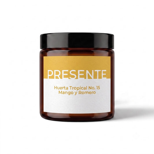 Vela aromática PRESENTE Taller Artesanal Huerta Tropical No. 15 de mango y romero en frasco de vidrio ámbar.