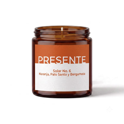 Vela aromática PRESENTE Taller Artesanal Solar No. 6 en frasco de vidrio ámbar con etiqueta de naranja y blanco.